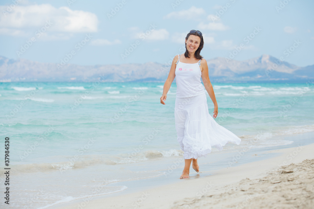 young woman walking near blue sea. young woman walking near blue sea.