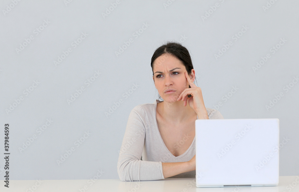 Jeune femme avec ordinateur portable sur fond gris Jeune femme avec ordinateur portable sur fond gris