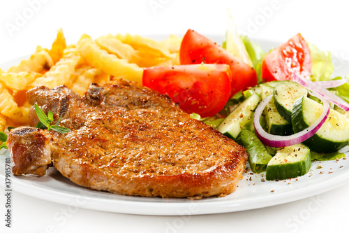 Fried pork chop with French fries and vegetable salad