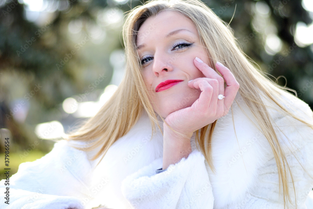 The young beautiful girl in a white fur coat with red lipstick The young beautiful girl in a white fur coat with red lipstick