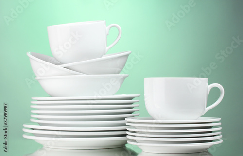 Clean plates, cups on green background