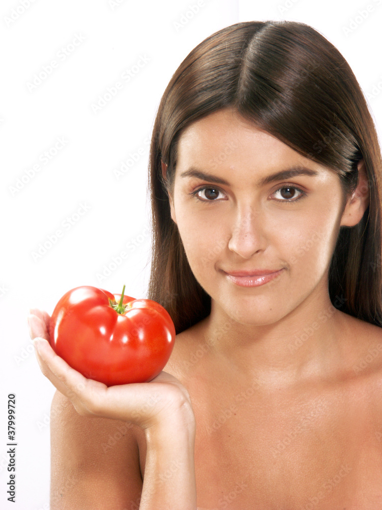 Joven mujer hispana sujetando un tomate fresco. Joven mujer hispana sujetando un tomate fresco.
