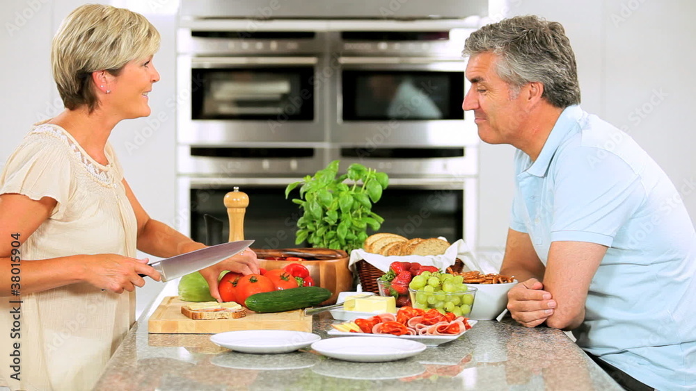 Mature Couple in Home Kitchen Preparing Lunch Mature Couple in Home Kitchen Preparing Lunch