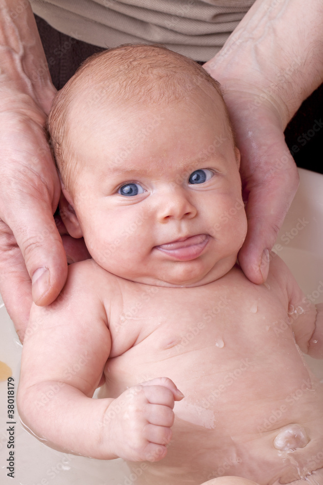 father bathing his newborn baby daughter for the first time. father bathing his newborn baby daughter for the first time.