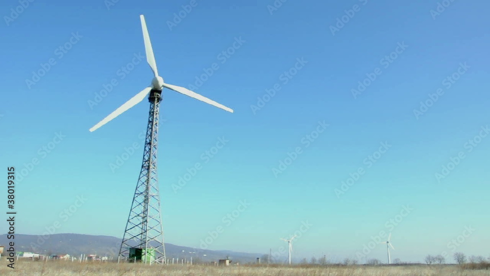 Wind generator on blue sky.