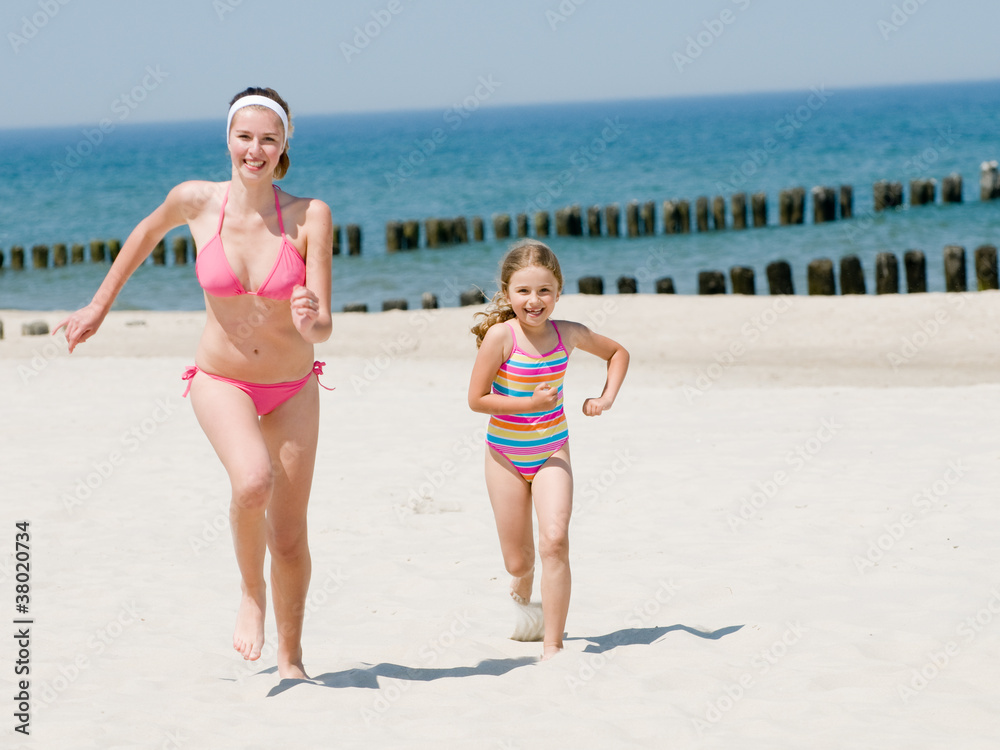 Naklejka premium Happy summer vacation - girls playing on the beach