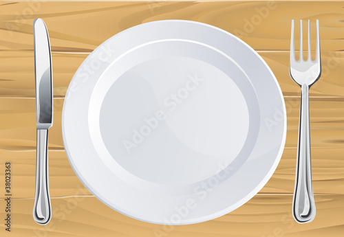 Plate and cutlery on wooden table
