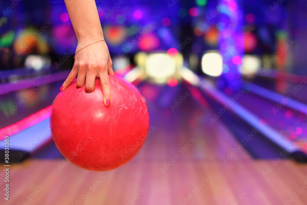 Fototapeta premium Female hand holding ball before throwing in bowling club