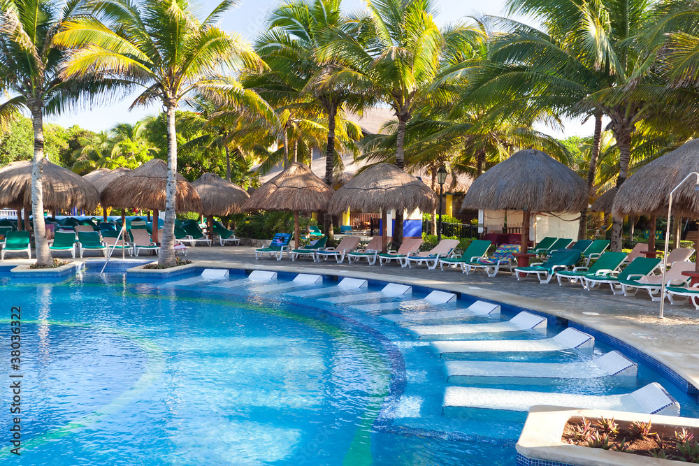 Tropical swimming pool with sunbeds in Mexico