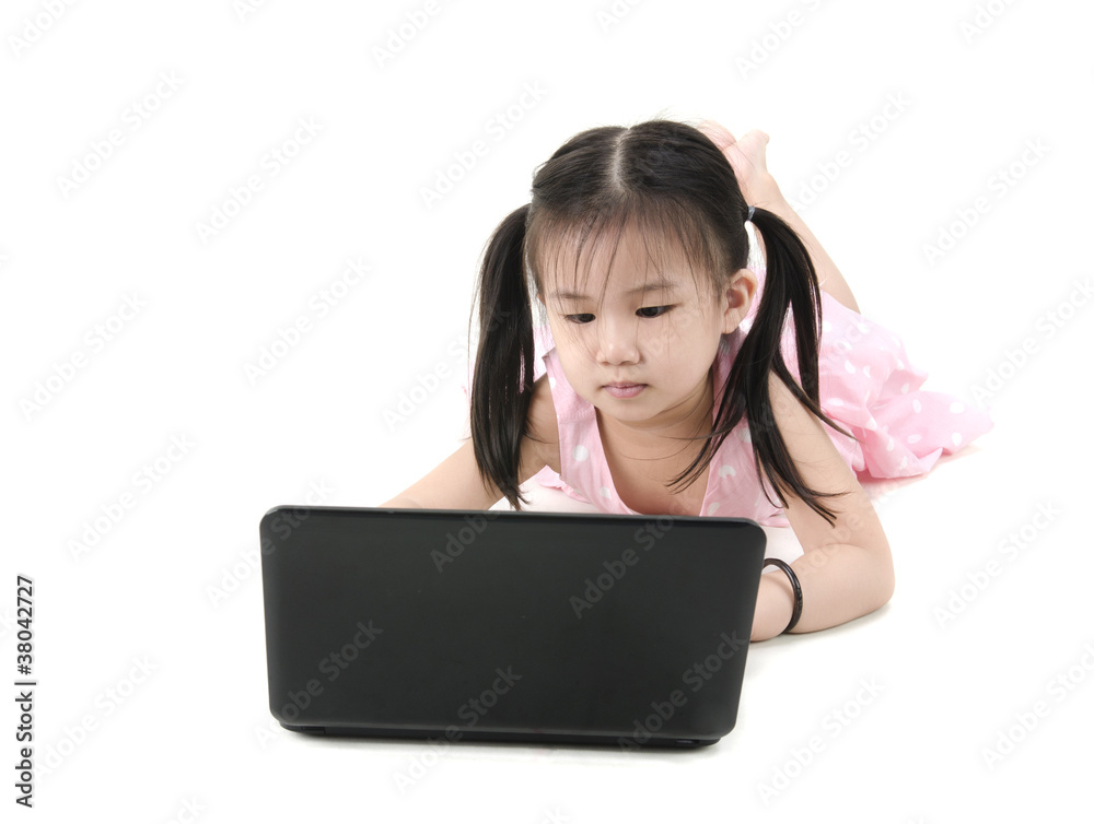 Beautiful little girl sitting on floor using a laptop, white bac Beautiful little girl sitting on floor using a laptop, white bac