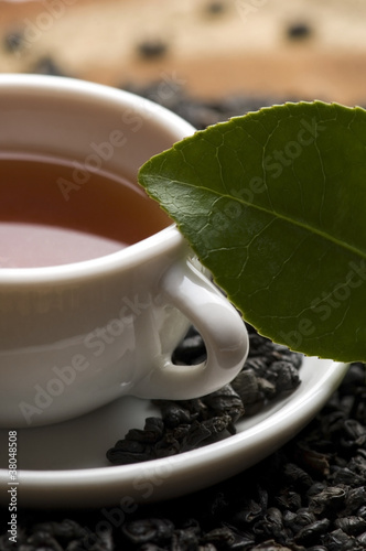 A cup of green tea with freh leaves photo