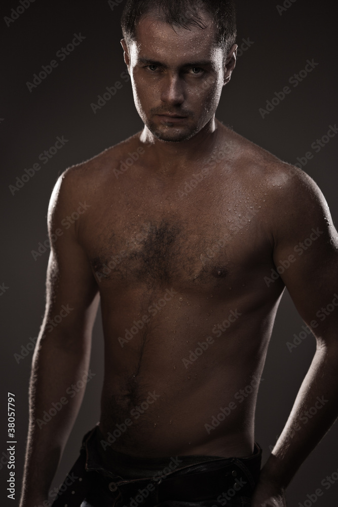 athletic young man with dewdrops on body