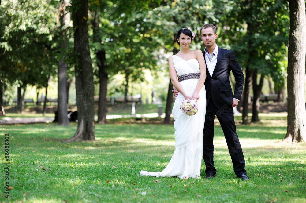Bride and groom posing outdoors on wedding day Bride and groom posing outdoors on wedding day