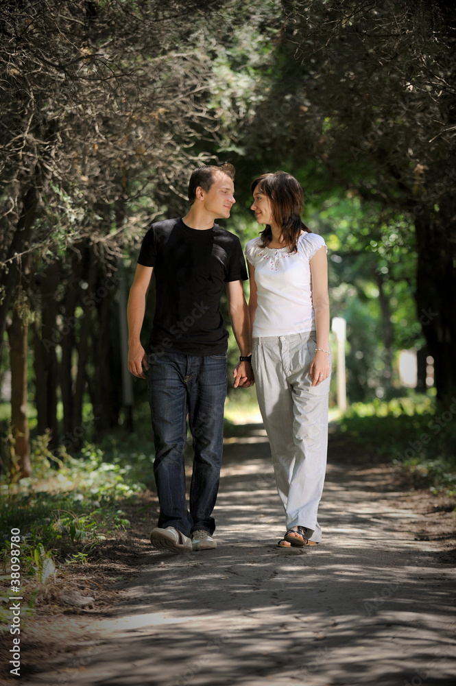 Young man and woman walking in the middle of an alley Young man and woman walking in the middle of an alley