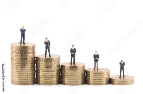 Business figures on stacks of coins