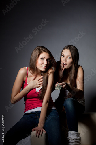 Two girls are watching TV
