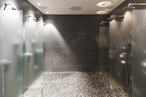 several showers seperated with walls of glass photo