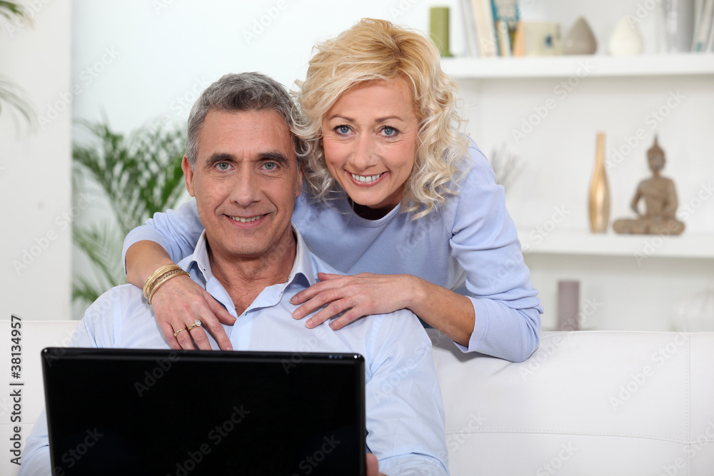 Mature couple using laptop at home Mature couple using laptop at home