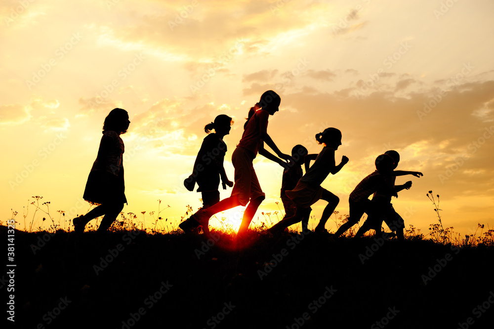 Silhouette, group of happy children on meadow, summertime Silhouette, group of happy children on meadow, summertime