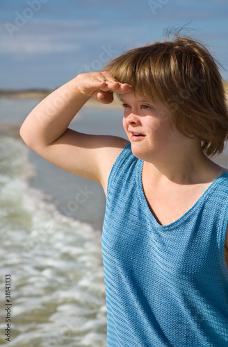 Girl at the beach looking out at the horizon.