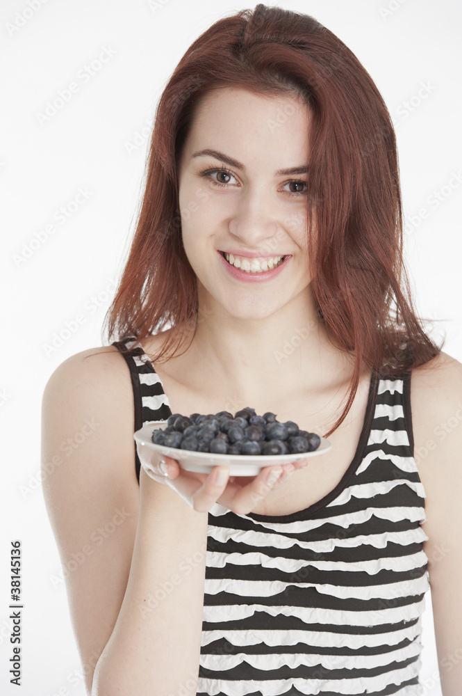 Young woman holding a plate with blueberries Young woman holding a plate with blueberries