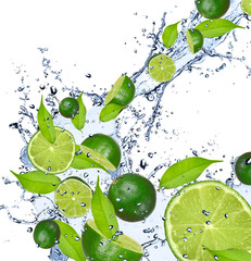 Küchenrückwand glas motiv Spritzendes Wasser Limetten fallen in Spritzwasser, isoliert auf weißem Hintergrund  © Jag_cz