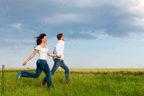 Happy couple running on a dirt road