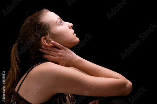 Young woman looking up against black background