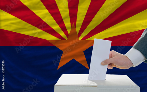 man voting on elections in front of flag US state flag of arizon