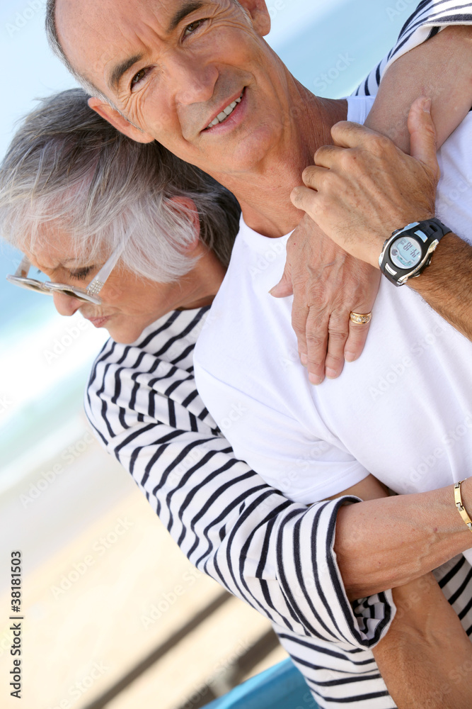 Middle-aged couple hugging at the beach Middle-aged couple hugging at the beach