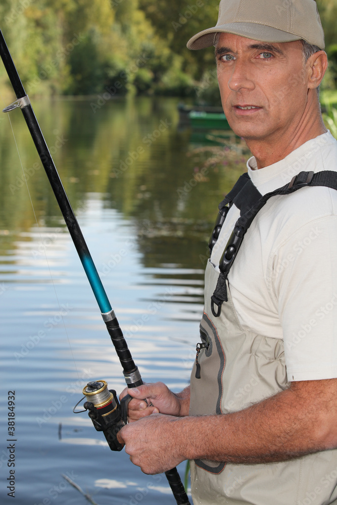 50 years old man fishing on the edge of a river 50 years old man fishing on the edge of a river