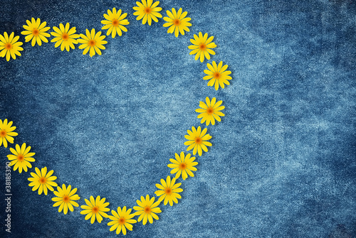 Heart made of flowers on jeans background