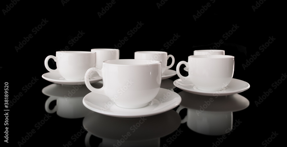 White cups and saucers on a black background White cups and saucers on a black background