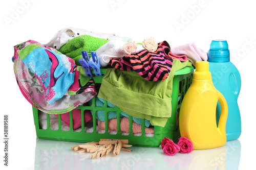 Clothes with detergent and in green plastic basket isolated photo