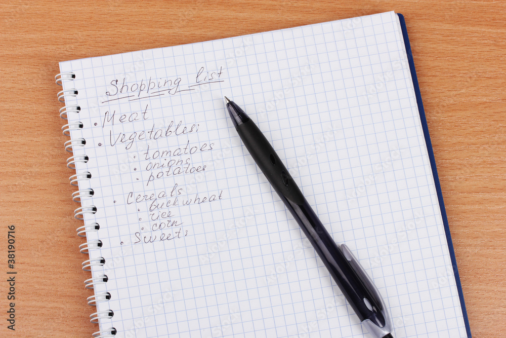Shoping list and pen on wooden table Shoping list and pen on wooden table