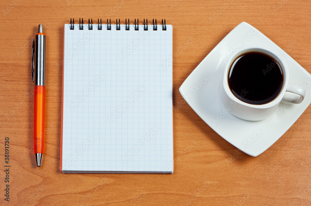 Pen, notebook and cup coffee on table. View from above. Pen, notebook and cup coffee on table. View from above.