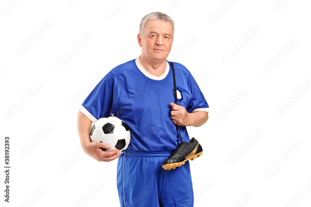 A senior wearing a sport wear holding a soccer shoes and footbal