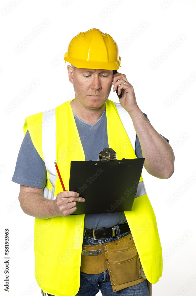 Construction worker phones and looks at clipboard Construction worker phones and looks at clipboard