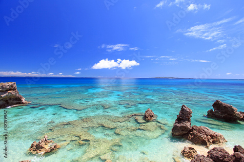コマカ島の澄んだ珊瑚礁の海と青い空
