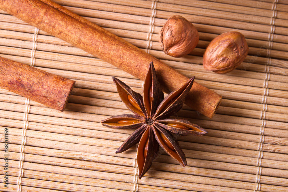 Closeup star anise and nuts on wooden bamboo mat