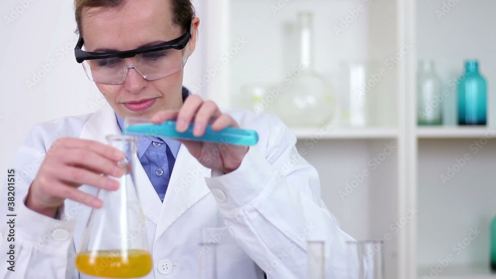 Female scientist mixing chemicals in erlenmeyer flask Female scientist mixing chemicals in erlenmeyer flask