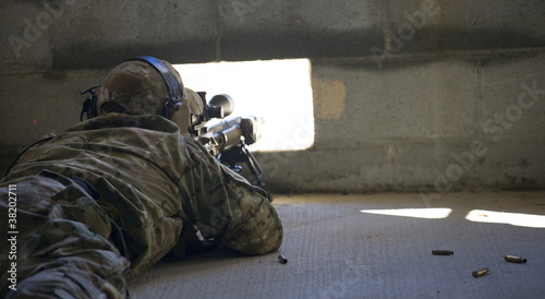 Bild auf Leinwand Shot from the Dark delivered by a military sniper in a brick building during a l