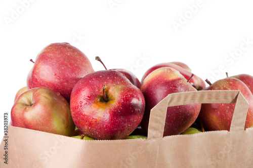 Grocery bag with fresh red apples, over white background
