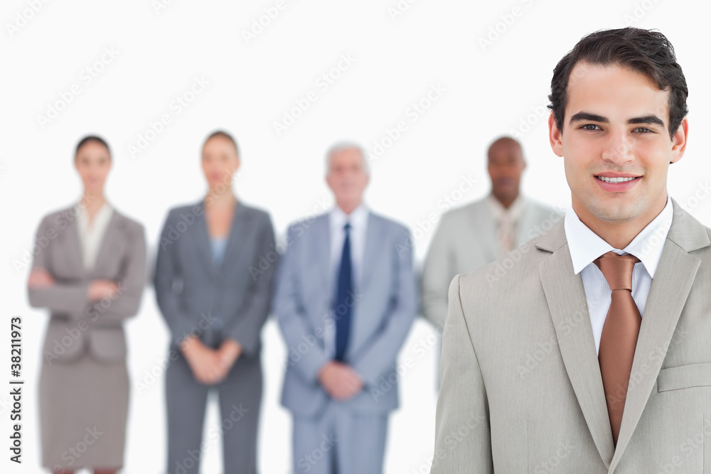 Smiling businessman with his team behind him Smiling businessman with his team behind him