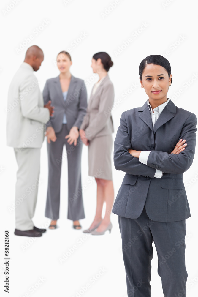 Confident saleswoman with negotiating trading partners behind he Confident saleswoman with negotiating trading partners behind he