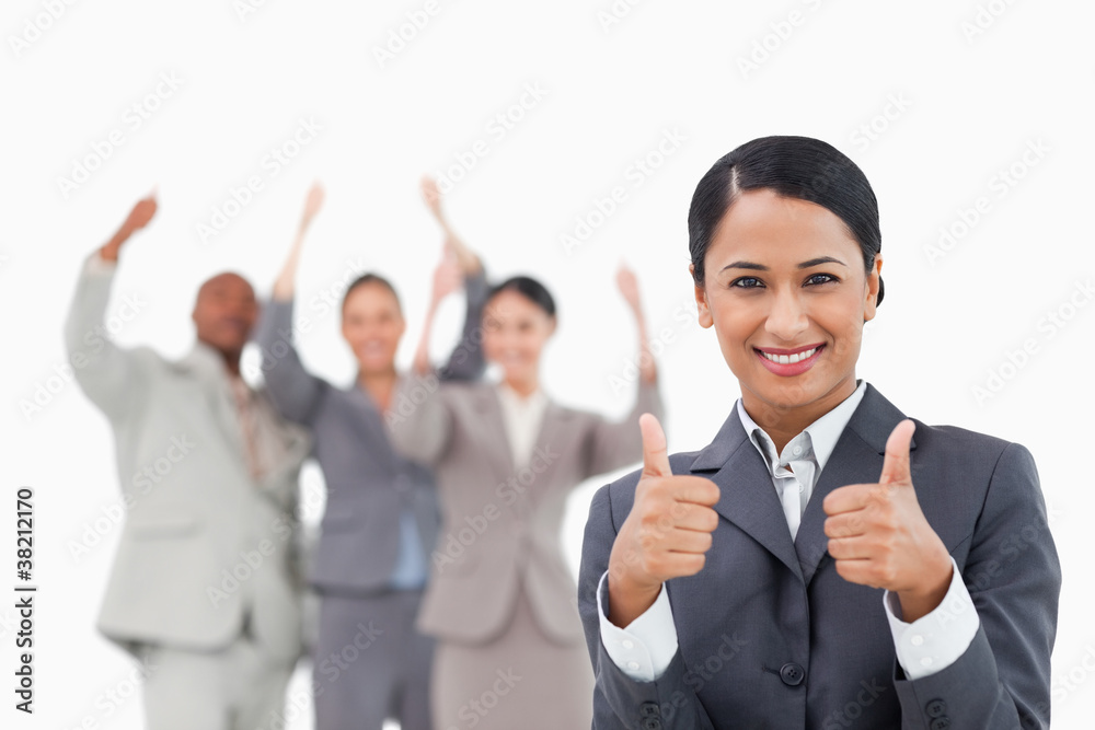 Saleswoman with cheering team behind her giving approval Saleswoman with cheering team behind her giving approval