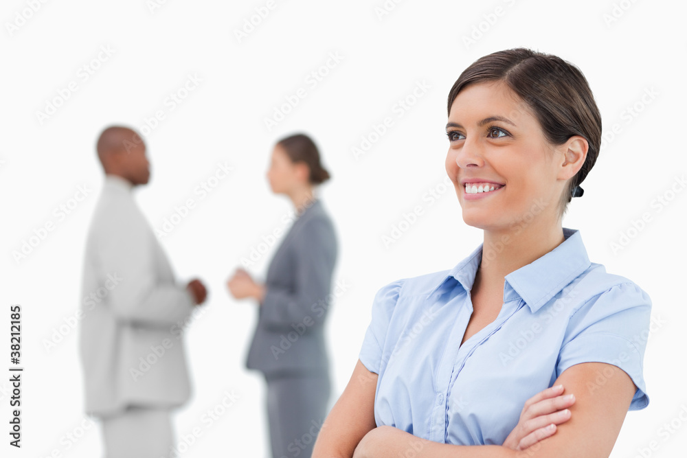 Smiling businesswoman with crossed arms and colleagues behind he Smiling businesswoman with crossed arms and colleagues behind he