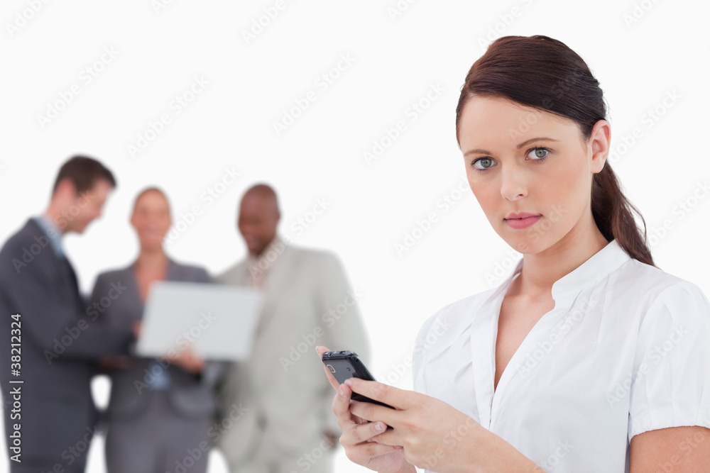 Tradeswoman with cellphone and associates behind her Tradeswoman with cellphone and associates behind her