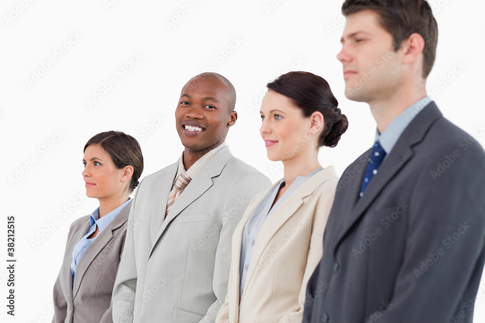 Smiling salesman standing between his colleagues Smiling salesman standing between his colleagues
