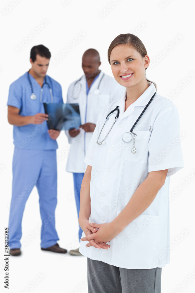 Smiling doctor with colleagues and x-ray behind her Smiling doctor with colleagues and x-ray behind her